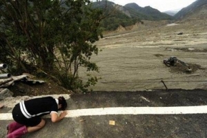 重災區高雄縣六龜某村落的一名婦女跪在地上哀悼死去的親人。（圖：法新社） <br/>