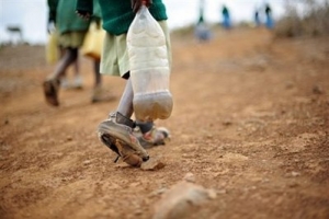 一名肯尼亞的小男孩用膠瓶子存起河水。（圖：法新社） <br/>
