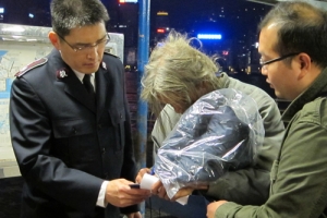 文化中心外的露宿者正簽收由救世軍人員送上的禦寒外衣。（圖：救世軍） <br/>