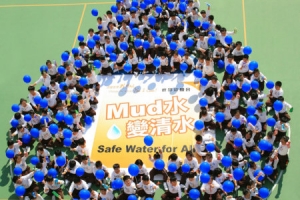 祖堯天主教小學約200名學生手持藍色氣球，於學校操場以身體砌成《Mud水變清水》的水滴點，並高呼「改變世界我可以！」的口號，以表達對貧困國家兒童飲用清水的關注及身體力行改變世界的決心。（圖：宣明會） <br/>