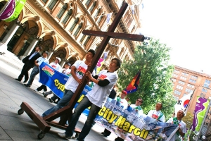 「雪梨聖城大遊行」隊伍由大型十字架打頭陣，浩浩蕩蕩地在市中心的主要大街上經過，吸引了不少圍觀者。（圖：本報記者） <br/>