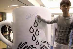 張敬軒特別在其親自為此次活動設計的「希望杯」上簽名，表示支持綠色和平防治水污染工作。（圖：中國新聞網） <br/>