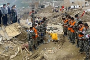 一隊救援人員在挖掘出來的屍體傍邊集體默哀。（圖：美聯社） <br/>