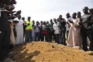 人們哀悼暴力事件的死難者，在墓前舉手禱告。（圖：路透社） <br/>