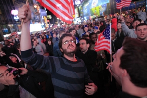 奧巴馬週日深夜宣佈拉登已死的消息後，有民眾聚集在紐約時代廣場慶祝，高舉美國國旗歡呼。（圖：路透社） <br/>