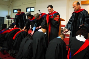 全體畢業生隨後跪下俯首接受衆神學院教師和牧者的訓勉與差遣。（圖：本報記者） <br/>