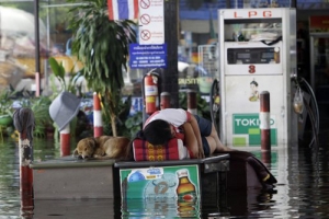 曼谷市區25日開始有水浸的情況，圖為一位工人在已被水淹的加油站外休息。（圖：美聯社） <br/>