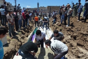 敘利亞中部霍姆斯省胡拉鎮曾發生嚴重的屠殺平民事件，造成至少108人死亡，其中有大量的兒童和婦女，圖為集體安葬的場面。（圖：路透社） <br/>