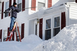 東北一居民於昨日雪停之後，清理屋頂的積雪。（圖：紐約時報） <br/>
