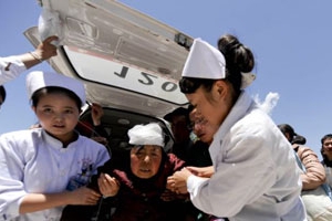 7月22日醫護人員從地震現場將一名受傷婦女送往醫院。（圖：路透社） <br/>
