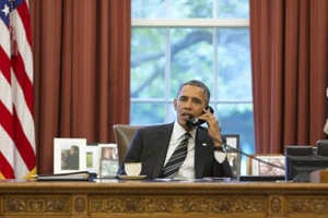奧巴馬在坐在白宮橢圓形辦公室的桌邊致電伊朗總統魯哈尼呼籲釋放薩伊德牧師。（圖：gettyimage） <br/>