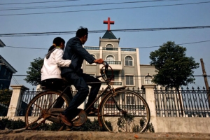 浙江杭州某郊區當地居民騎車路過大教堂。（圖：路透社） <br/>