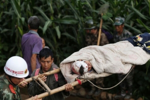救援人員用臨時搭製的擔架把受傷男童抬出來。（圖：路透社） <br/>