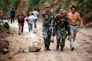 雲南公安局已調動1.1萬名警力集中救人，他們從災場把傷者背出來。（圖：路透社） <br/>