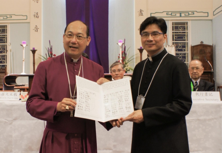 郭志丕主教從鄺保羅主教手上接過已簽署的《選舉確認書》。(圖：聖公會)