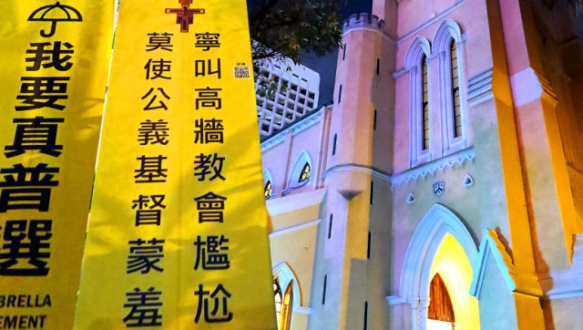 靜坐人士在香港中環聖約翰座堂對出草地掛起的標語。(圖：網絡)