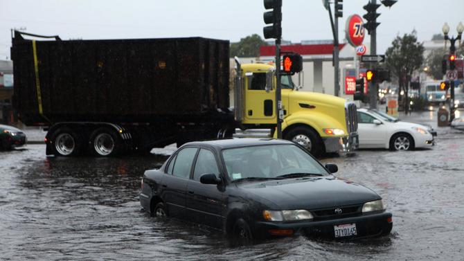南舊金山區的Airport Blvd與Grand Ave附近有水浸，有駕駛者的汽車故障，需要棄車離開，(圖:美聯社)