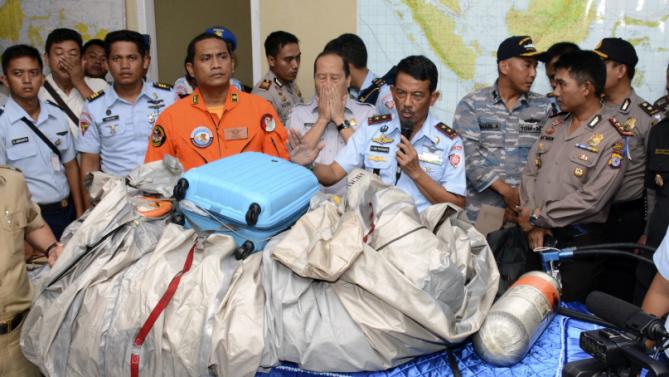 印尼空軍司令在12月30日的記者會上展示在爪哇海域上的飛機殘骸，以及一個相信屬於乘客的行李箱。(圖:美聯社)