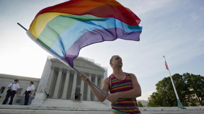 美國最高法院1月16日宣布同意審理同性婚姻是否合乎聯邦憲法，此最終裁決預料將結束全國各州廿年來在同性婚姻合法化問題上的爭議。圖為2013年6月一名同志運動人士在美國最高法院門外揮動同志彩虹旗。(圖:美聯社)