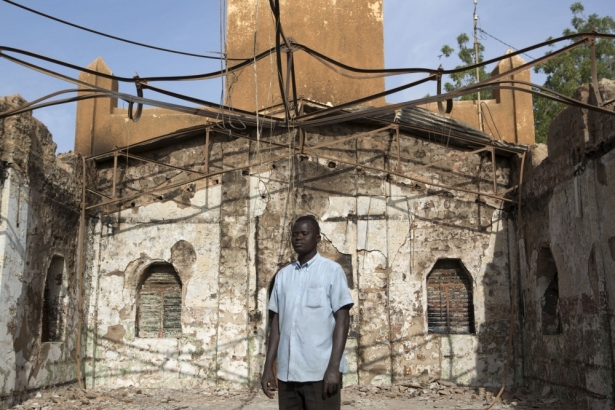 一位信徒站在尼日爾一所遇襲的教會門外。(路透社)