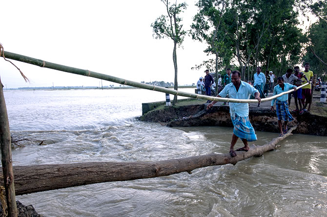 一些偏遠村落的出入道路被水淹沒，村民暫時用樹幹搭建成小橋，方便出入。(圖：宣明會)