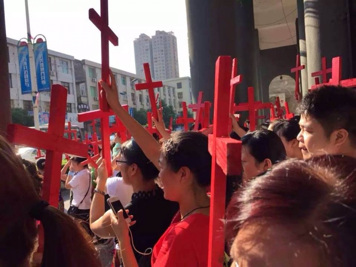 溫州信徒拿起自製的小十字架，抗議政府強拆十字架。