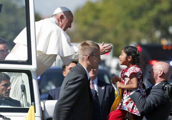 羅馬天主教教宗方濟親民形象，贏得美國民眾的心。2015年9月23日，教宗方濟在華府街頭路過時，與一位夾道歡迎他的小女孩握手。(Alex Brandon/Pool via Reuters)