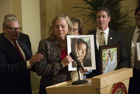 29歲的腦癌患者布列塔妮‧梅納德的母親手持女兒的照片出現在加州眾議院，支持安樂死法案通過。