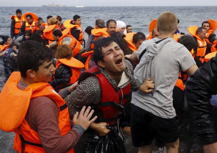 一名敘利亞難民從土耳其海岸橫渡愛琴海後，到達了希臘島嶼萊斯沃斯島。他從一條超載的小船上下來時忍不住抱頭痛哭，(路透社)