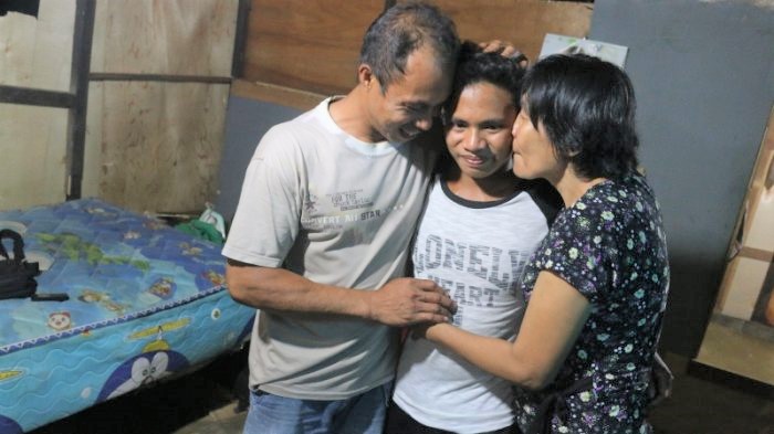 阿迪（中間）獲救後回家與父母重聚。（圖：Tribun Manado - Tribunnews.com）