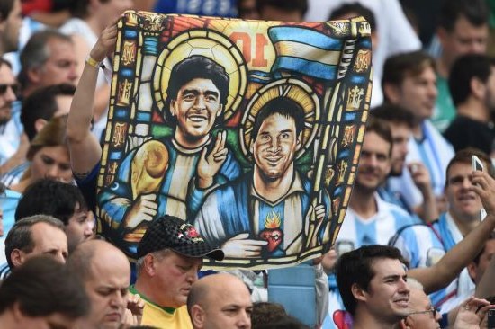 阿根廷球迷舉起印有美斯和馬勒當拿上帝形象的旗幟。（圖：網絡圖片）
