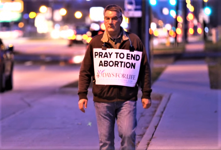 義工穿上巨型海報「為結束墮胎祈禱」在街道行走喚起國人關注。（圖：40 Days for Life facebook）