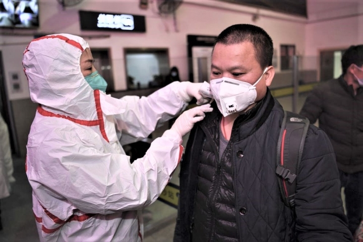 中國防疫人員為旅客量體溫。（圖：中新社）