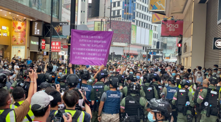 今年10月1日國慶日大批市民上街示威，執法人員舉旗示警。（圖：Studio Incendo） 