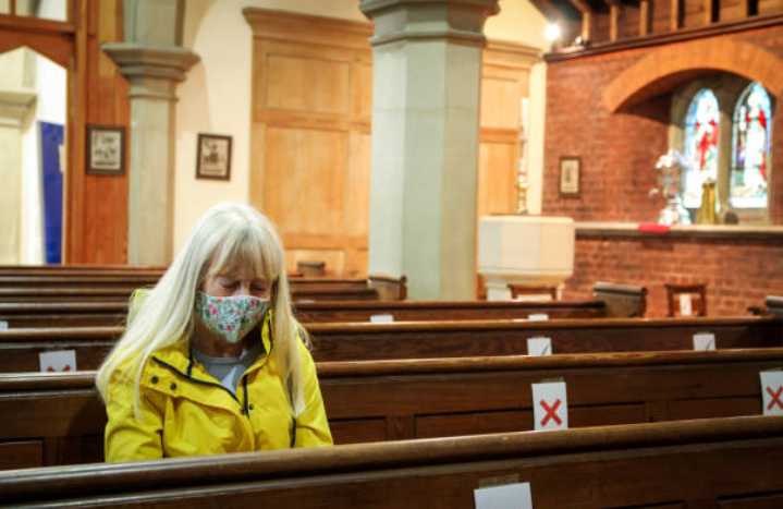 婦人戴上口罩在教堂祈禱。（圖：Getty Images）