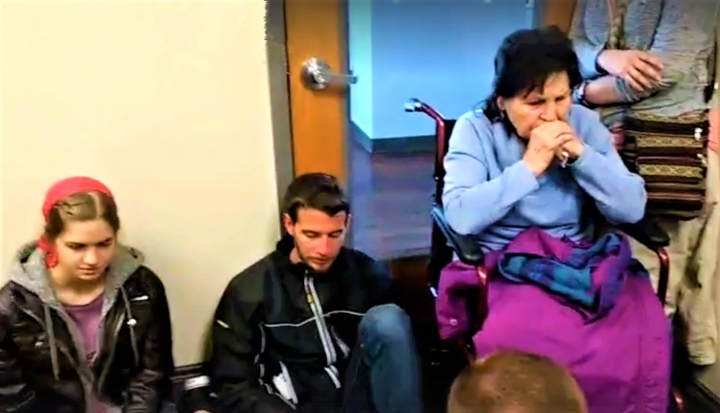 坐著輪椅二戰倖存者伊娃與基督徒守在門前阻止婦女進入墮胎。（圖：視頻擷圖） 