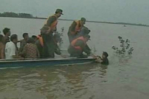 救援隊伍從水中搶救一名遇險災民。 <br/>