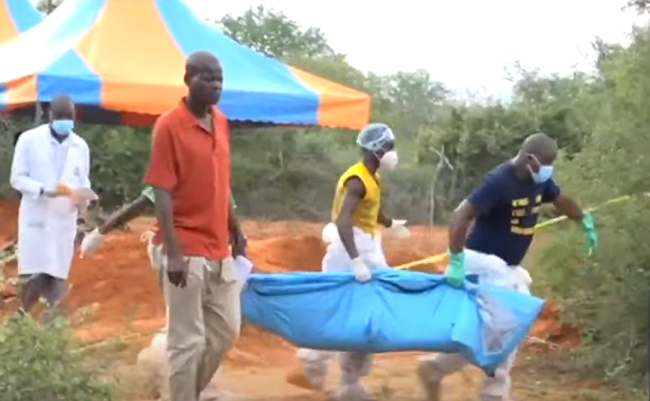 工作人員在森林挖出挨餓致死的教徒屍體。（圖：Citizen TV Kenya視頻擷圖）