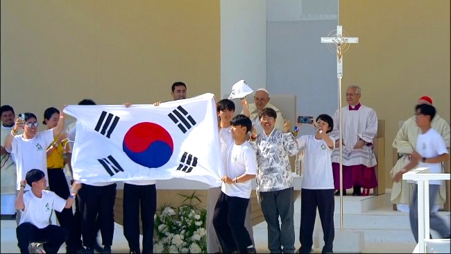 韓國青年在台上興奮地揮舞國旗。（圖：梵蒂岡新聞網）