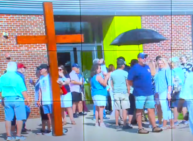 人群持巨型十字架聚集圖書館門前。（圖：WHNT News 19擷圖）