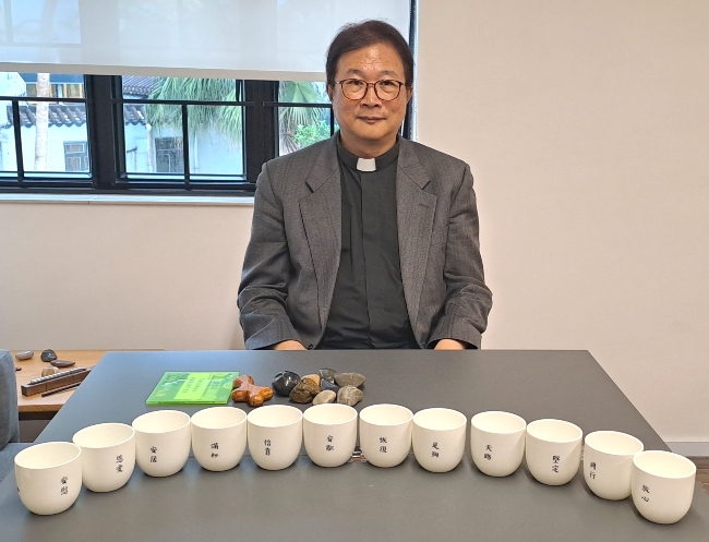 劉文亮牧師與12陶瓷杯。（圖：基督日報）
