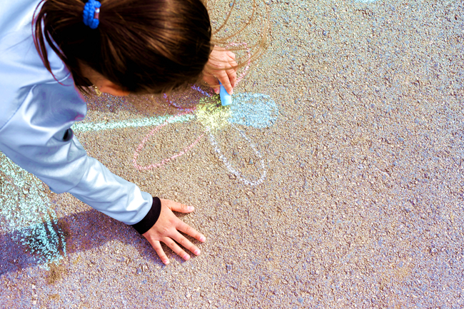 女孩在路上用粉筆畫畫。（示意圖：freepik）