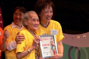 年屆九十六歲的黃湘明婆婆(左)則奪得「女松柏大獎」，為今年活動中最年長的參加者，圖為她從香港世界宣明會董事會主席王䓪鳴博士(右)手中接過獎狀。（圖：香港世界宣明會） <br/>