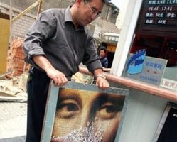 6月9日，北京一間電影院的工作人員將「達文西密碼」電影海報撤下。中國廣電總局下令全國自6月9日零時起停映此片。（AP Photo/Greg Baker） <br/>