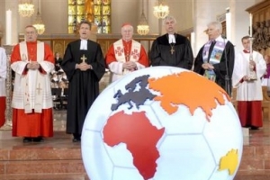 在世界杯開始前的“Kickoff2006”開始禮拜上，教會領袖們站在附有世界地圖的巨大的英式足球前一起帶領大家爲世界杯和平祈禱。（圖：美聯社） <br/>