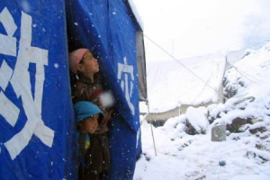 在巴基斯坦管轄的喀什米爾Pieer Chanasi村，小朋友從帳篷探頭張望外面的大風雪。 <br/>