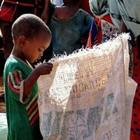一个非洲儿童手中拿着一个空的食品袋(来源:联合国世界粮食援助署) <br/>
