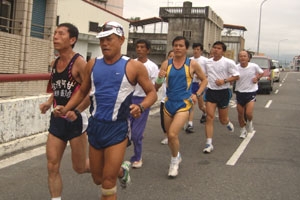 平時跑步的時候，阿甘（前左）靠著引導繩，跟著吳興傳教練一起跑。 <br/>