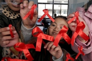 中國江蘇省南京的一所小學的學生正在把象徵關懷愛滋的紅絲帶貼上。（圖：美聯社） <br/>