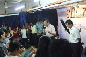 來自英語衛理公會的Andrew Tan牧師帶領眾人，一起舉起禱告的手，將一切獻上給神。（圖：基督新報） <br/>